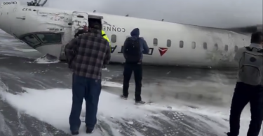 people standing next to a plane